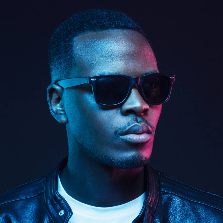 Neon portrait of african american male model wearing trendy sunglasses and leather jacket